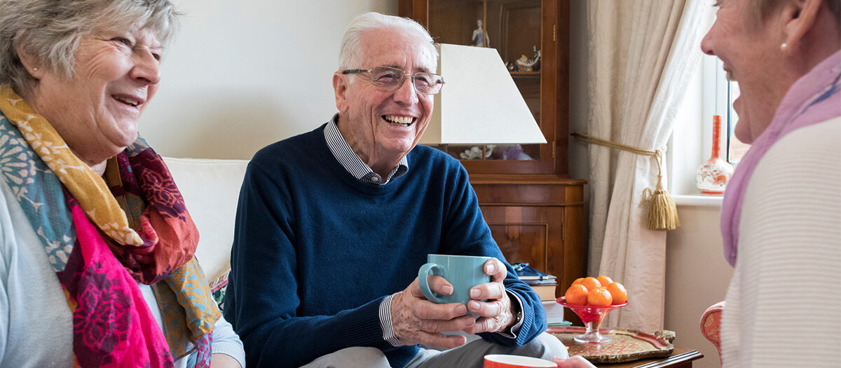 Group of senior friends chatting over coffee